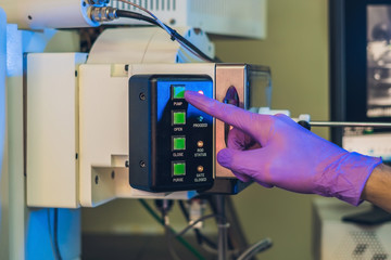 Scientist in a laboratory works with an electron microscope gateway. Putting a sample into a...