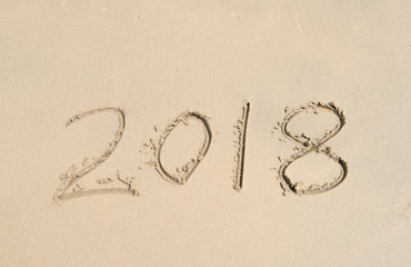 2018 written in sand write on tropical beach