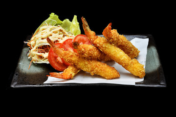 Japanese cuisine deep fried shrimps with vegetables salad with black isolated background