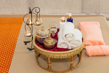Fototapeta na wymiar Massage item and Spa Oil in Basket on Bed