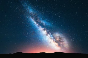 Foto op Canvas Milky Way. Fantastic night landscape with bright milky way, sky full of stars, yellow light and hills. Shiny stars. Picturesque scene with our universe. Space background. Amazing astrophotography © den-belitsky