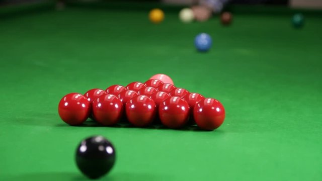 Starting a game of Snooker by breaking the pack of reds