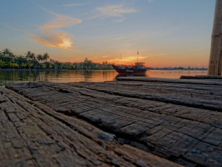 Fototapeta na wymiar Wood, boat and sunrise