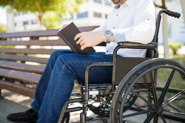 Man in wheelchair reading a book