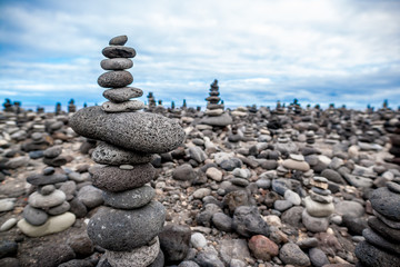 Pyramid of the small pebbles on the beach. Stones, against the background of the blue sky.Shallow dept of field.