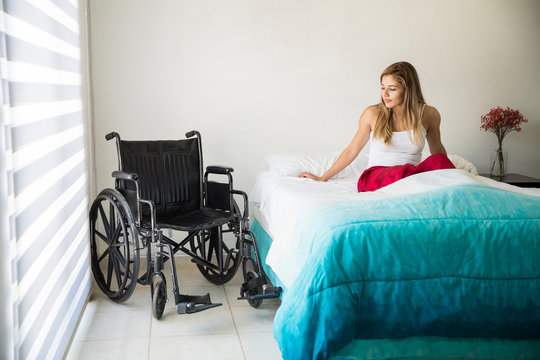Sad paralyzed woman in bed