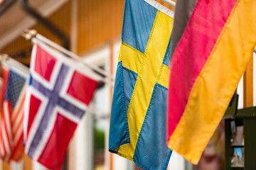 Flags on wall of building in Sigtuna, Sweden.