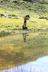 Man taking a photograph with his mobile reflected on a lake