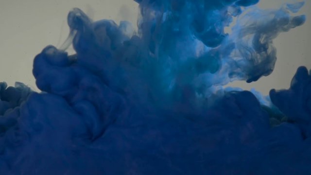 Blue color paint pouring in water. Acrylic colors and ink in water. Abstract frame background. Colors and ink in water