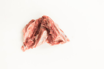 A piece of raw meat against a white cutting board in a butchers shop/ deli market