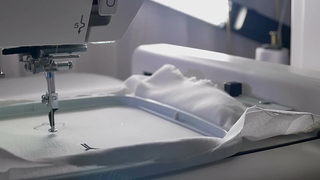 Machine embroidery work.Working embroidery machine. Textile - Professional and industrial embroidery machine. Needle moves quickly, embroidering a pattern