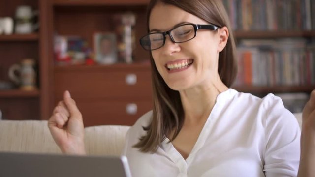 Businesswoman using laptop at home, professional female recieving good news excited cheerful smiling