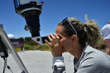 woman tourist looking through big telescope