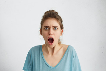 Emotional woman opening her mouth widely screaming loudly being dissatisfied with something expressing her disagreement and annoyance. Female shouting at her boyfriend who is late for their date