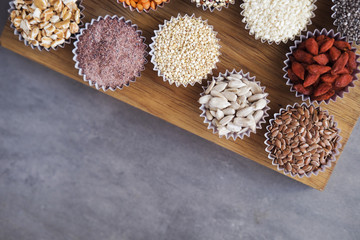 Various superfoods, seeds, cereals, grains on a gray background. Healthy eating concept. Top view