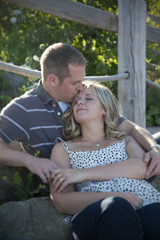 Fototapeta premium a couple enjoys being outside together, man kissing woman's forehead