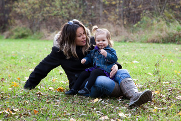 Fototapeta premium A mother and her daughter sitting in the grass.