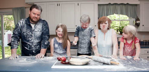  an angry family in the kitchen after a food fight and baking an apple pie.        