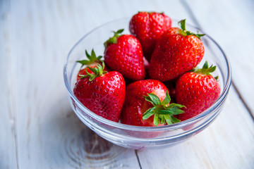 Strawberries on the plate on white wooden background for breakfast 