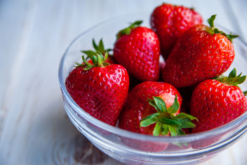 Strawberries on the plate on white wooden background for breakfast 