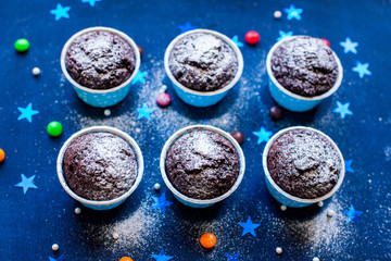 Christmas cupcakes with light, wooden background, stars, and christmas tree