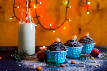 Christmas cupcakes with light, wooden background, stars, and christmas tree