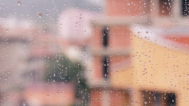 Window With Raindrops On It And Blurred Town Behind Slow Slide Footage