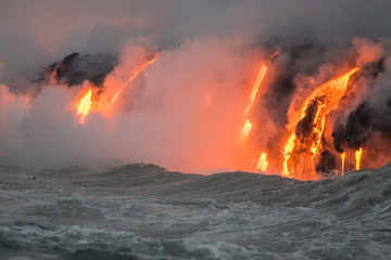 Molten lava flowing into the Pacific Ocean on Big Island of Hawaii at sunrise