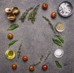 Obraz na płótnie Canvas Ingredients for cooking vegetarian Food, herbs and seasonings, cherry tomatoes, basil and butter Lined with a frame on a granite table, place for text