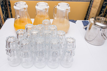 Buffet allestito con brocche e bicchieri in cristallo per la consumazione di succhi di frutta