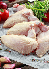 Raw Chicken breast supremes fillets with chilli, pepper corns and thyme. With asparagus and tomatoes for side dish