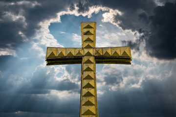   golden cross isolated with cloudy sky background -