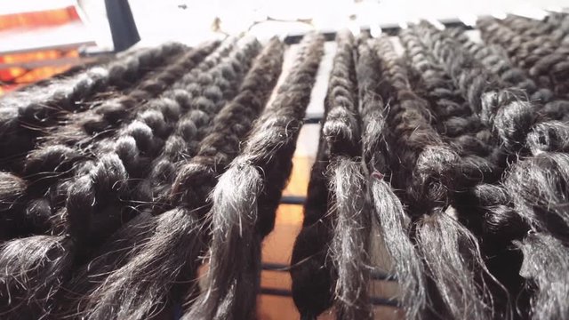 Hair extensions, black braids hanging display in a Bolivian market