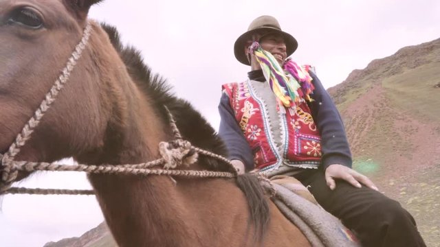 Peruvian muleteer mounts horse wearing the typical costume of the highlands. Slow motion