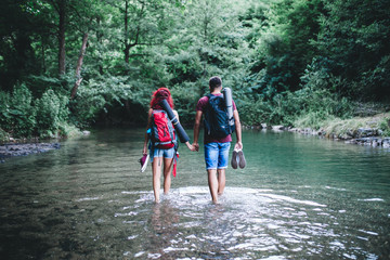 Young happy couple enjoying together in wild mountain river.