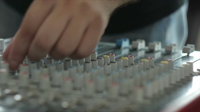 Professional audio operator working on audio mixer