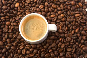 White little cup and many coffee beans