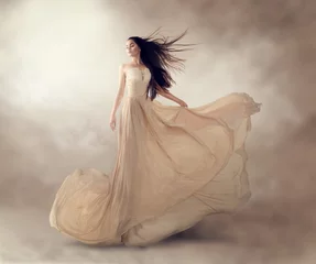 Modemodell in wunderschönem, luxuriösem, beigefarbenem, fließendem Chiffonkleid © Subbotina Anna