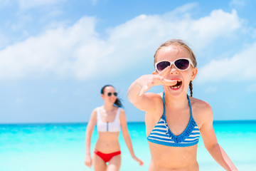 Obraz premium Little girl and young mother at tropical beach