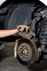 Girl inspects the calipers of a break from a pickup