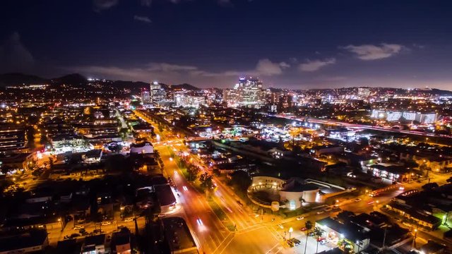 Aerial timelapse at night with a busy freeway and intersection and passing traffic in view.