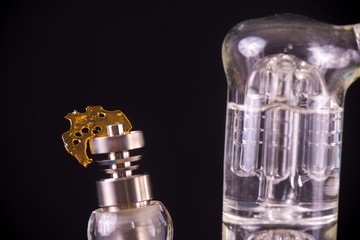 Dabbing tool with small piece of cannabis oil aka shatter - medical marijuana concentrates concept