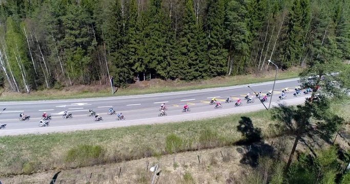Bicycle race, Cinema 4k aerial rising view of a group of cyclists, racing on a cycle competition event, on a summer day, just outside Nuuksio national park, in Espoo, Finland