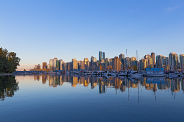 Vancouver downtown skyline reflection at sunset, Canada. Scenic urban landscape as seen from Stanley Park.