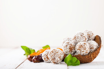 Homemade dietary candies from dates and an apricot in coconut topping. Selective focus. Copy space
