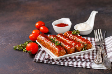 Meat sausages and sauces on an dark background. Selective focus. Copy space