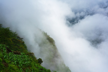 Naklejka na ściany i meble Green mountains cliff and white clouds