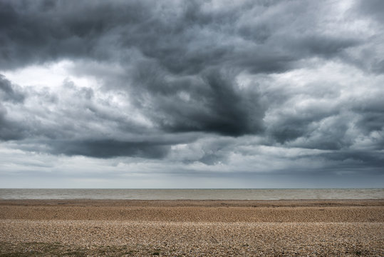 Dramatic storm clouds building over Winter beach landscape