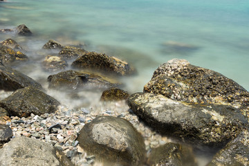 Stone in sea and wave on morning time with long exposure.