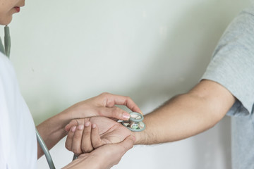 Closeup of stethoscope on patient's hand.